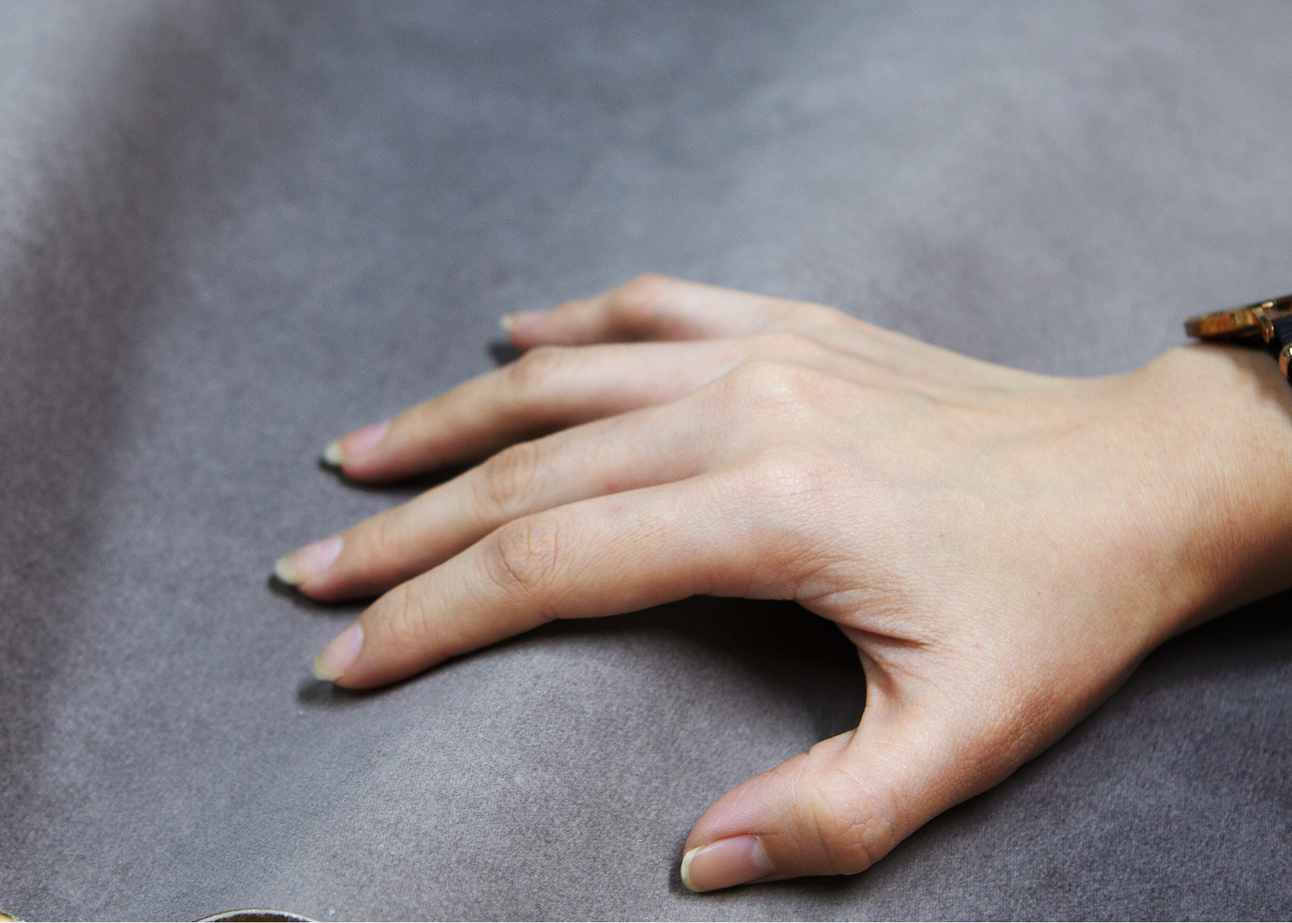 Hand resting on a gray fabric surface